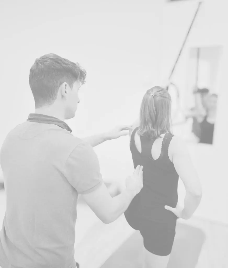 Therapeut überprüft die Körperhaltung einer Patientin während einer Behandlung